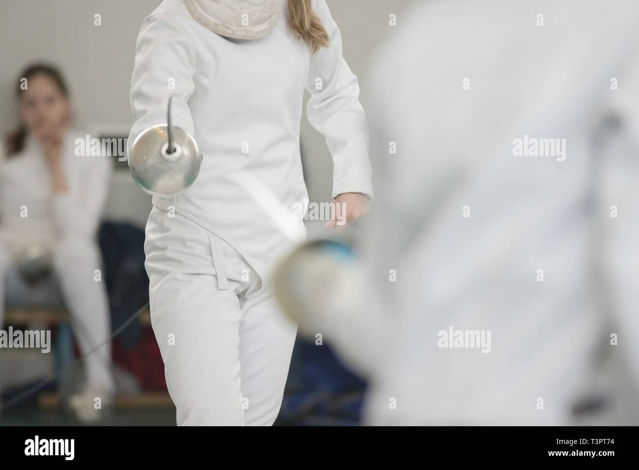 Due giovani donne schermitori praticanti duello di scherma Foto Stock