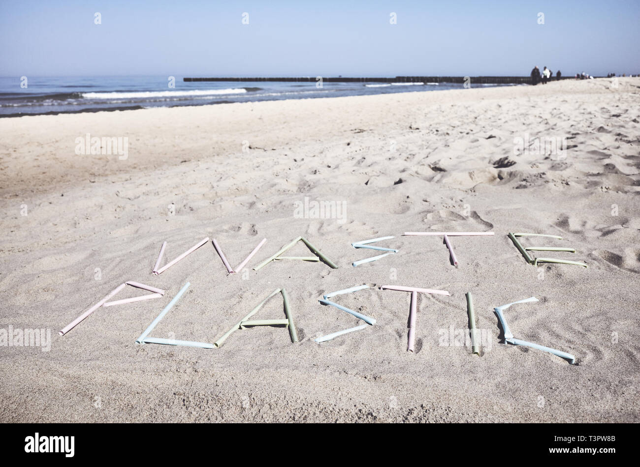 Rifiuti di plastica parola fatta di cannucce di plastica sulla sabbia, dai toni di colore foto, messa a fuoco selettiva. Foto Stock