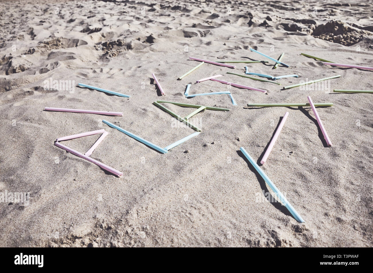 Parola di plastica fatti di cannucce di plastica sulla sabbia, dai toni di colore foto, messa a fuoco selettiva. Foto Stock