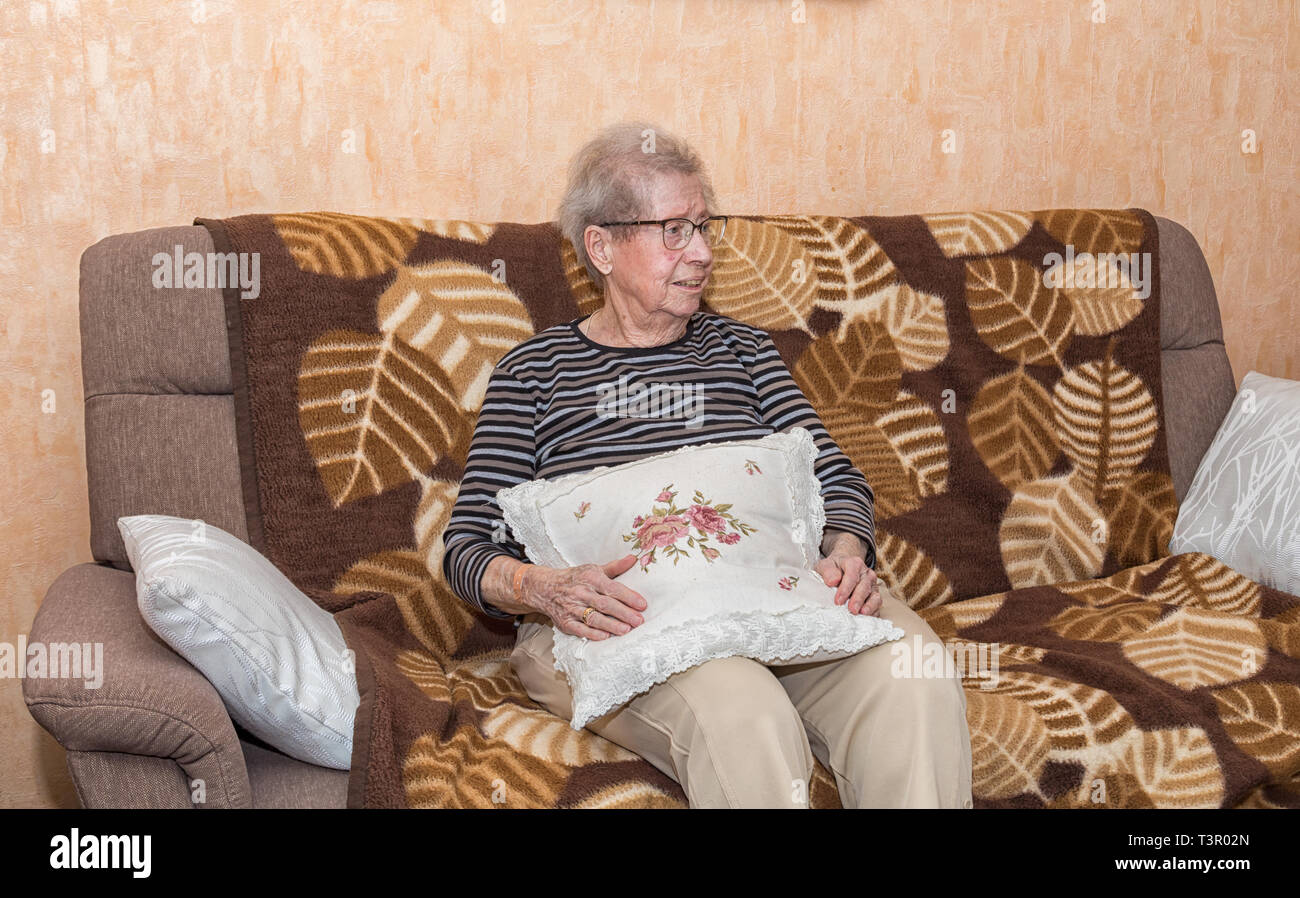 Oltre 80 anno vecchia nonna seduta su un divano Foto Stock