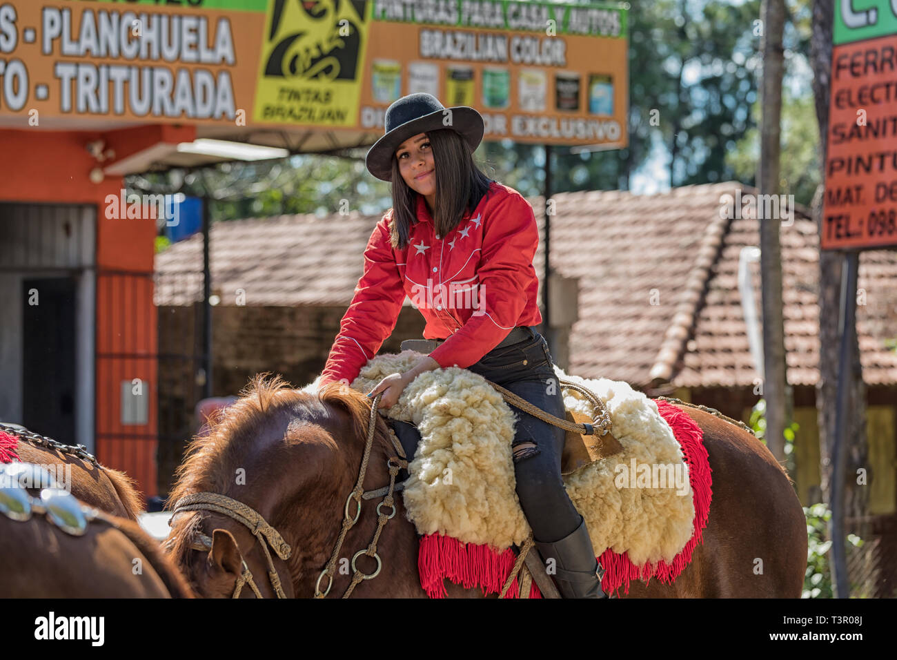 Colonia Independencia, Paraguay - 14 Maggio 2018: una bella donna orgogliosamente cavalca il suo cavallo durante il paraguaiano annuale Giorno Di Indipendenza parade. Ella ci Foto Stock