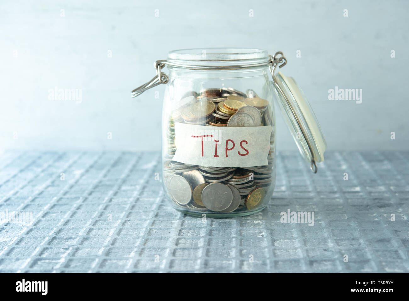 Monete in denaro di vetro vaso con suggerimenti etichetta, concetto finanziario. Foto Stock