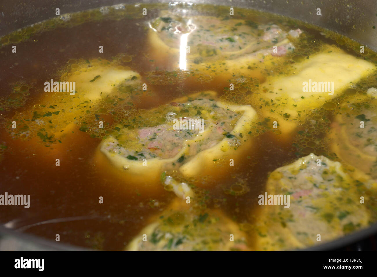 Sveva di ravioli con il ripieno di spinaci e carne in zuppa come antipasto, laminati in casa sveva ravioli di carne galleggianti in brodo caldo in una pentola di metallo Foto Stock
