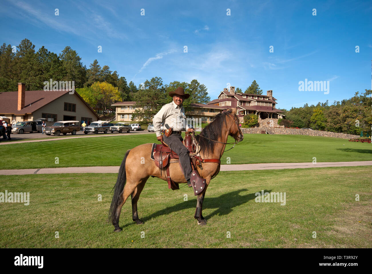 Ranger del Parco sul suo cavallo vicino lo stato Game Lodge (in background), Custer State Park, Black Hills, Dakota del Sud, STATI UNITI D'AMERICA Foto Stock