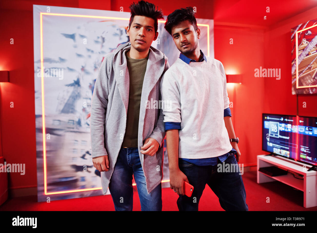 Due ragazzi asiatici poste al red giochi tv sala giochi. Foto Stock