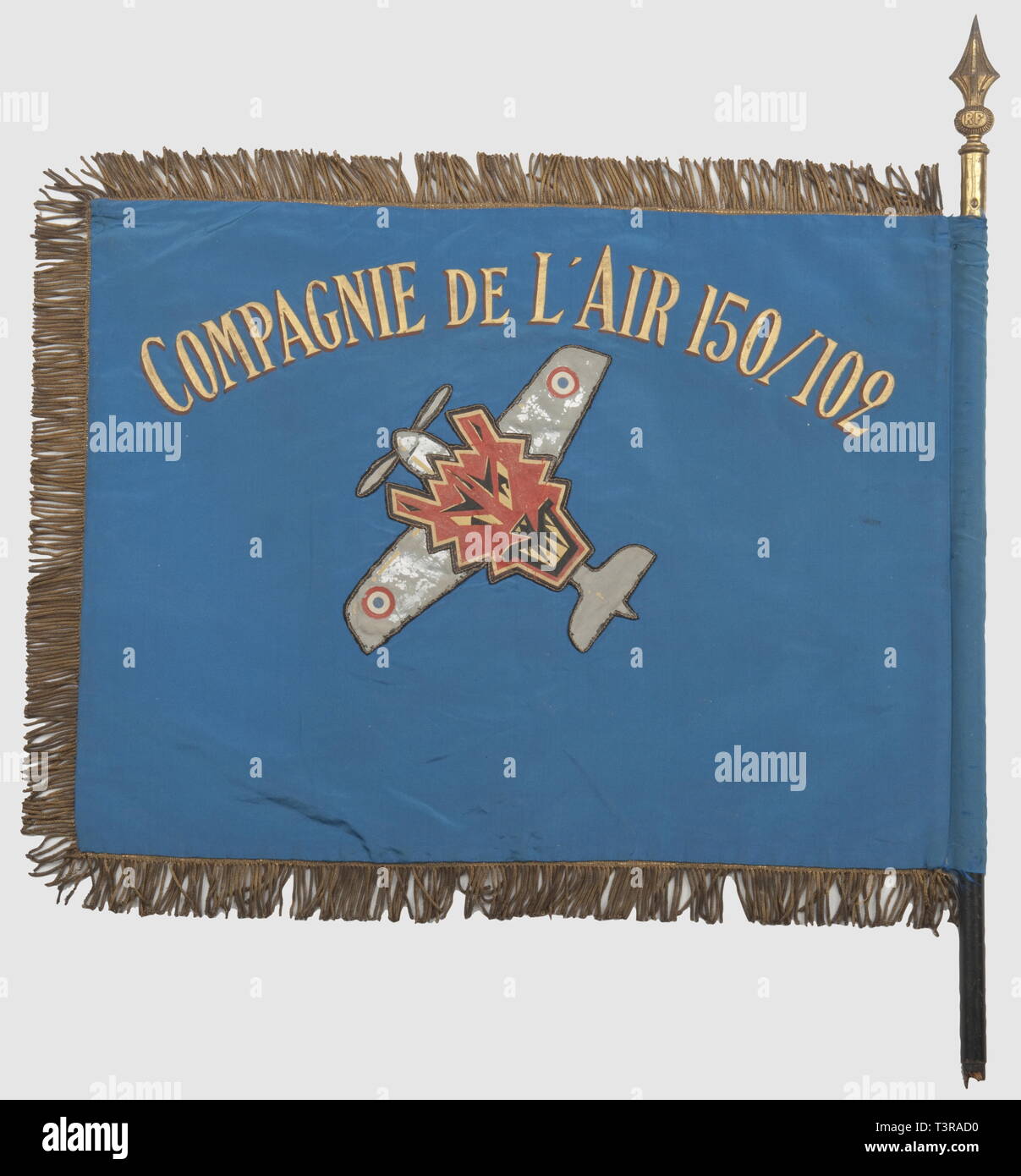 FANIONS ET DRAPEAUX, Fanion de la Compagnie de l'aria 150/102, satiné Tissu bleu ciel avec, de chaque côté, iscrizioni et insigne peints, ce dernier réalisé en une partie rapportée, avec son souligné pourtour d'onu fil d'or et d'onu fil noir. L'insigne représente une tête de loup (?) brochant sur onu avion à hélice gris métallisé, orné des cocardes tricolores francaises (cet emblème existe sous la forme d'onu rari insigne métallique). Franges dorées sur le pourtour, excepté côté hampe, celle-ci est en bois peint avec l'extrémité munie d'une pointe v, Additional-Rights-Clearance-Info-Not-Available Foto Stock