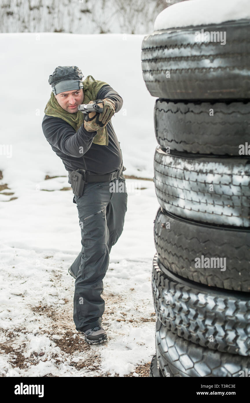 Pistola di combattimento addestramento al tiro da dietro e intorno al coperchio o barricade. Advanced combattimenti tattici corsi di tiro sul poligono di tiro Foto Stock