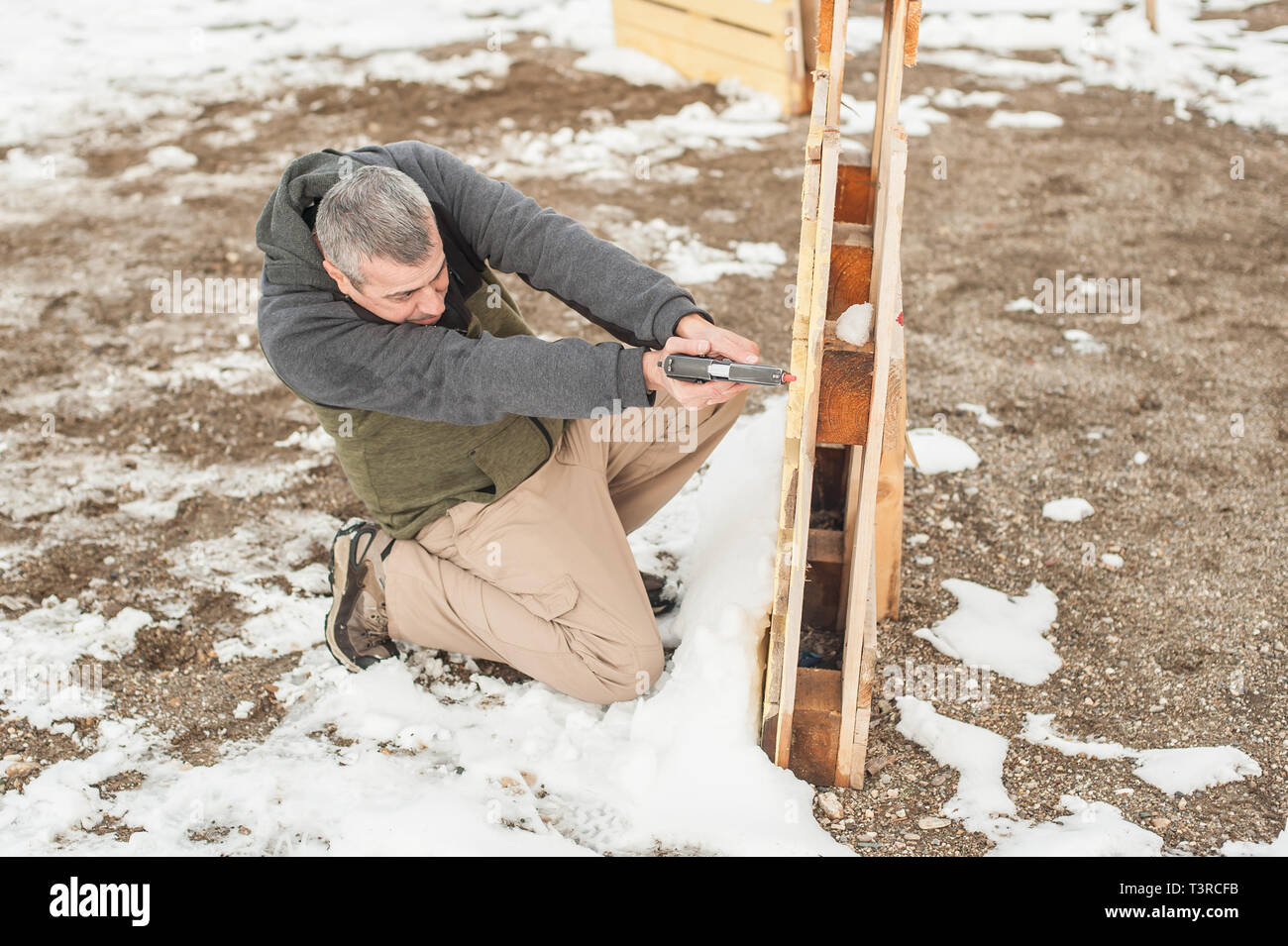 Istruttore di dimostrare la posizione del corpo della pistola di combattimento di scatti da dietro il coperchio o barricade. Advanced combattimenti tattici corsi di tiro su ra di ripresa Foto Stock