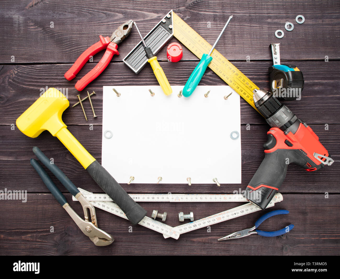 La costruzione utensili su sfondo di legno intorno al foglio di carta  bianco Foto stock - Alamy