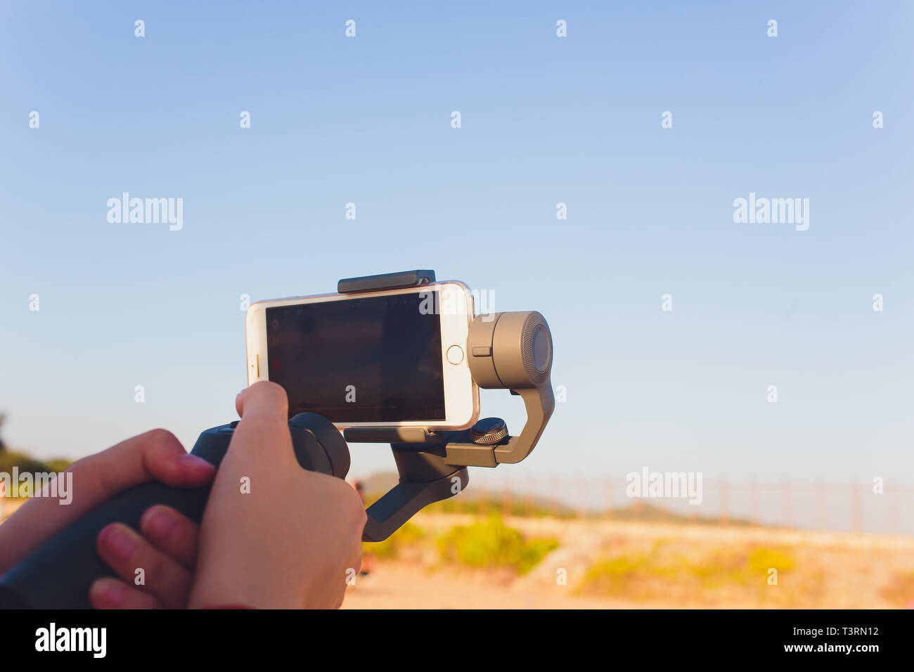 I germogli di persona al telefono con un manuale elettronico stabilizzatore. Close-up. Vista frontale. Foto Stock