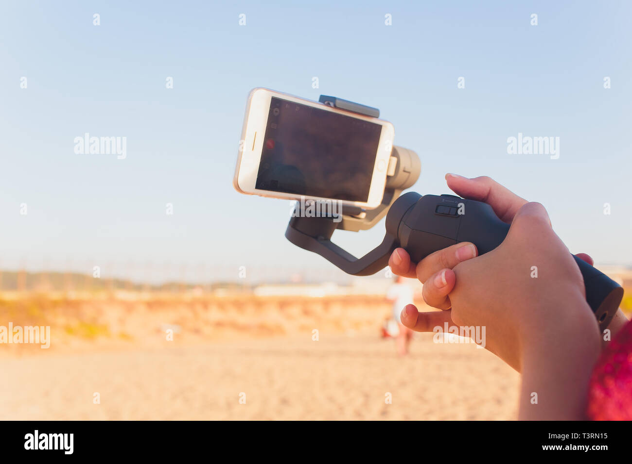 I germogli di persona al telefono con un manuale elettronico stabilizzatore. Close-up. Vista frontale. Foto Stock