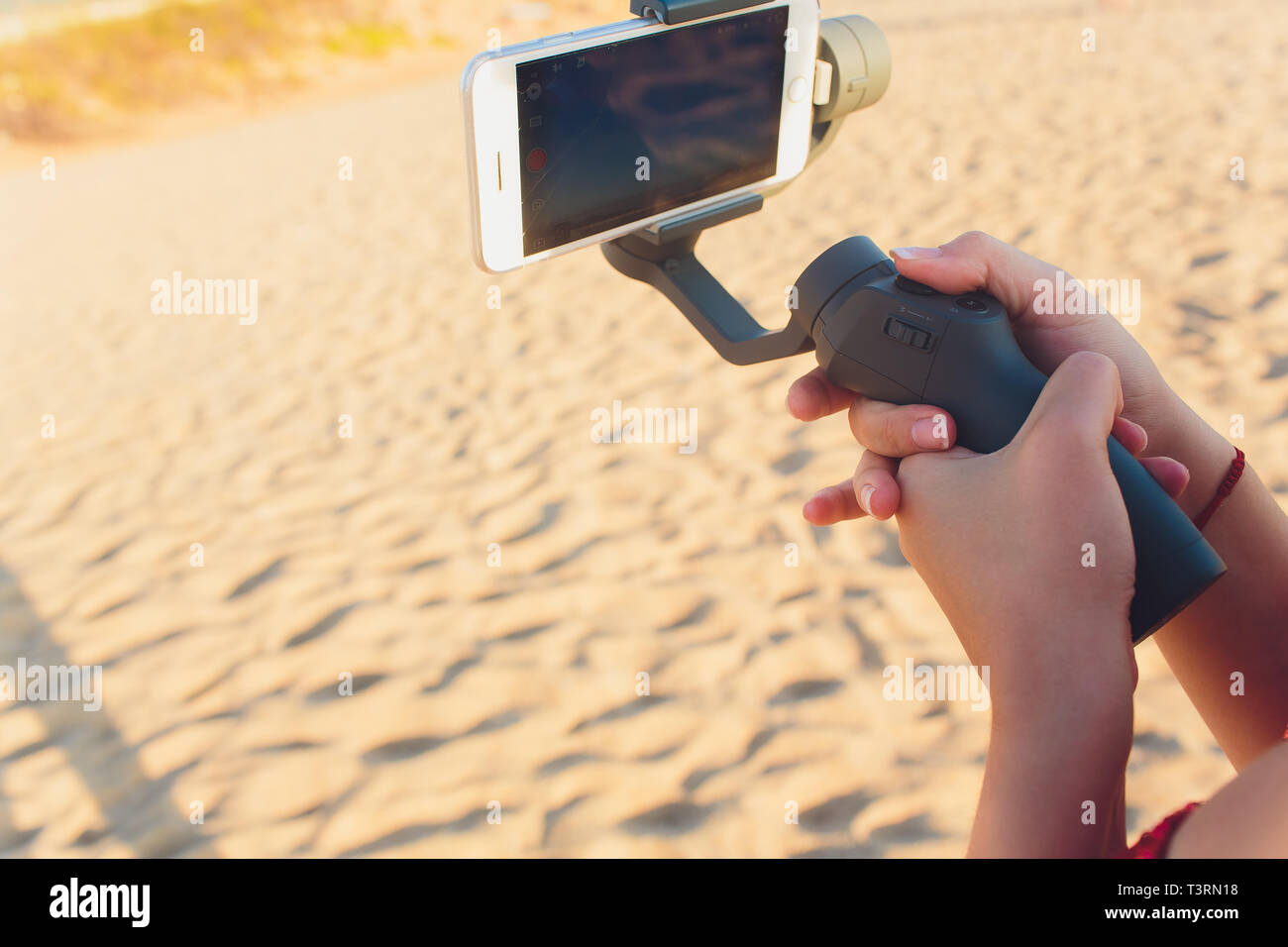 I germogli di persona al telefono con un manuale elettronico stabilizzatore. Close-up. Vista frontale. Foto Stock