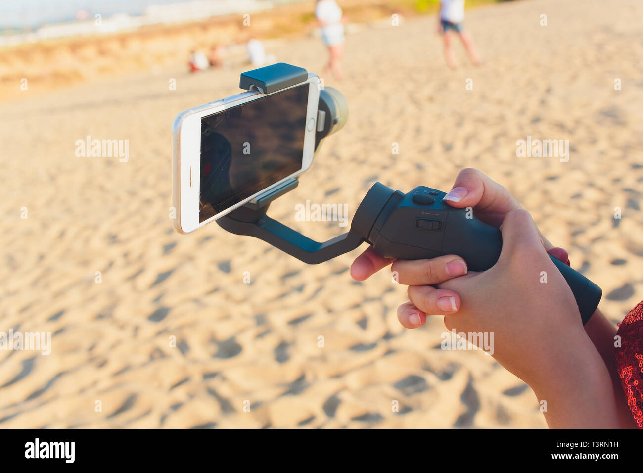 I germogli di persona al telefono con un manuale elettronico stabilizzatore. Close-up. Vista frontale. Foto Stock