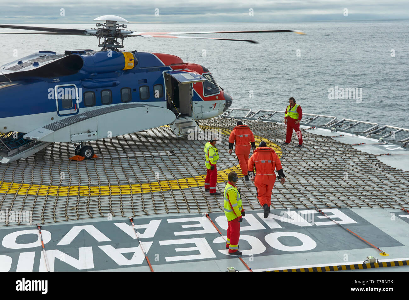 Un CHC S92 Sikorsky elicottero sul ponte di una nave sismica in Norvegia Mare del Nord conducendo equipaggio cambia per 2 passeggeri. Norvegia Foto Stock