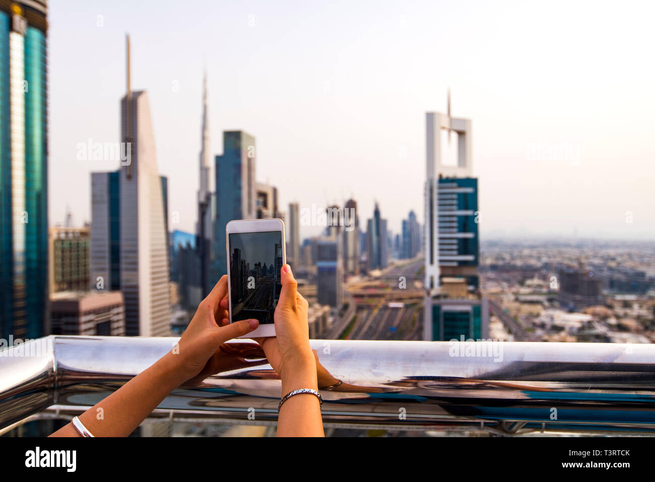 Donna prendendo foto di Dubai cityscape tramite telefono Foto Stock