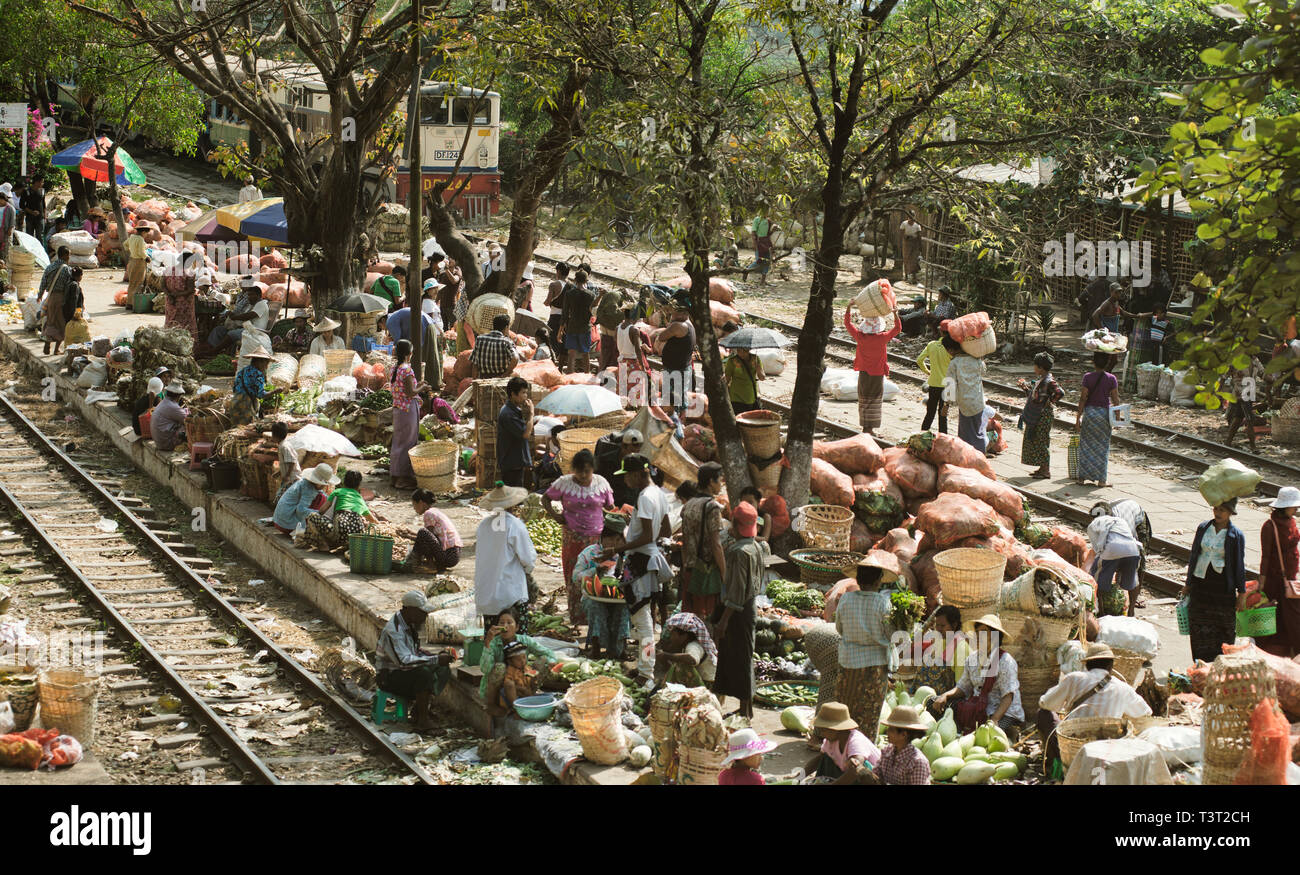 Affollato mercato di frutta e verdura sulla piattaforma della stazione e lungo il binario. Febbraio 22, 2014 - Danyingon stazione ferroviaria, Yangon, Myanmar Foto Stock