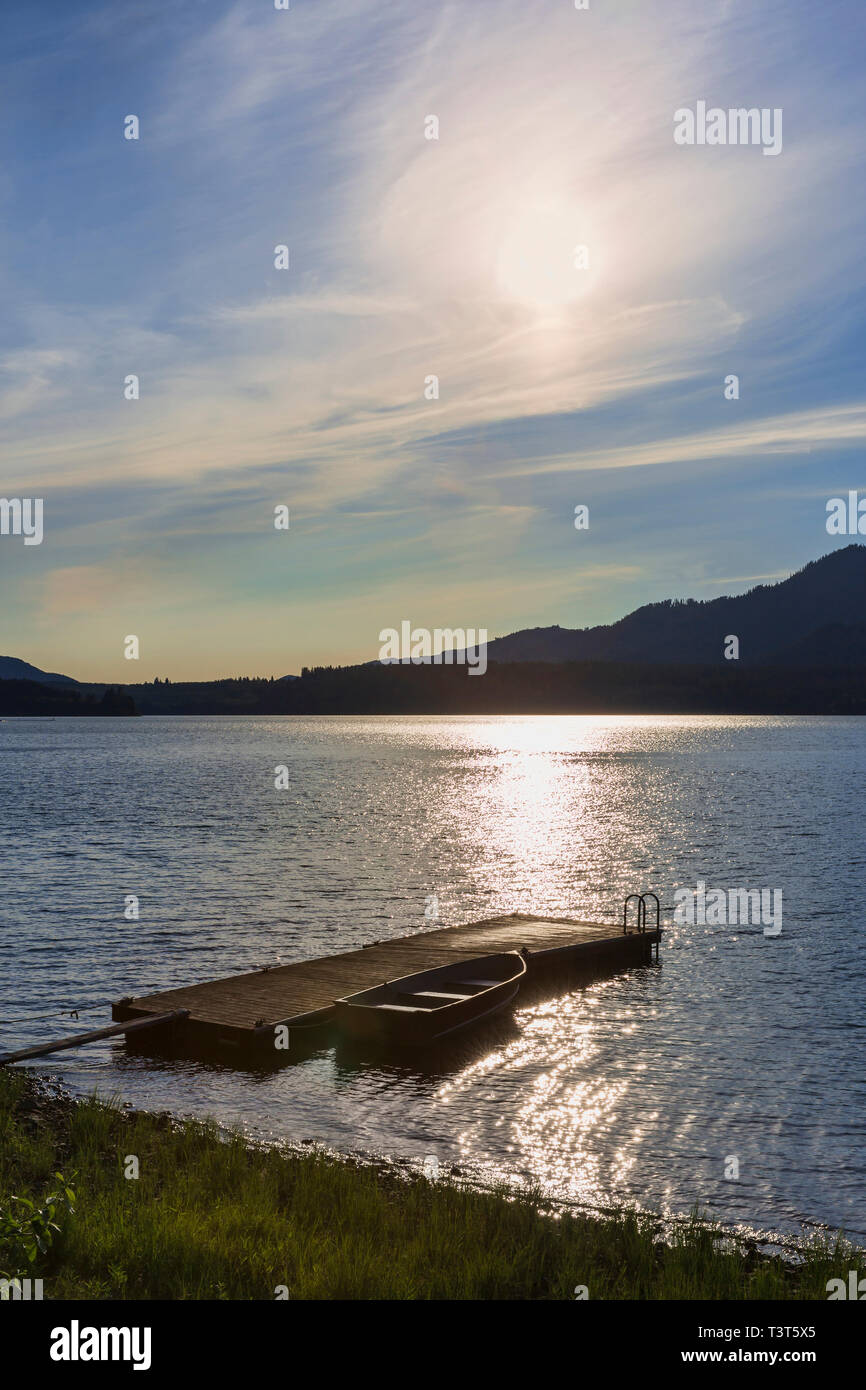 Canoa e dock in legno nel lago in remoto Foto Stock