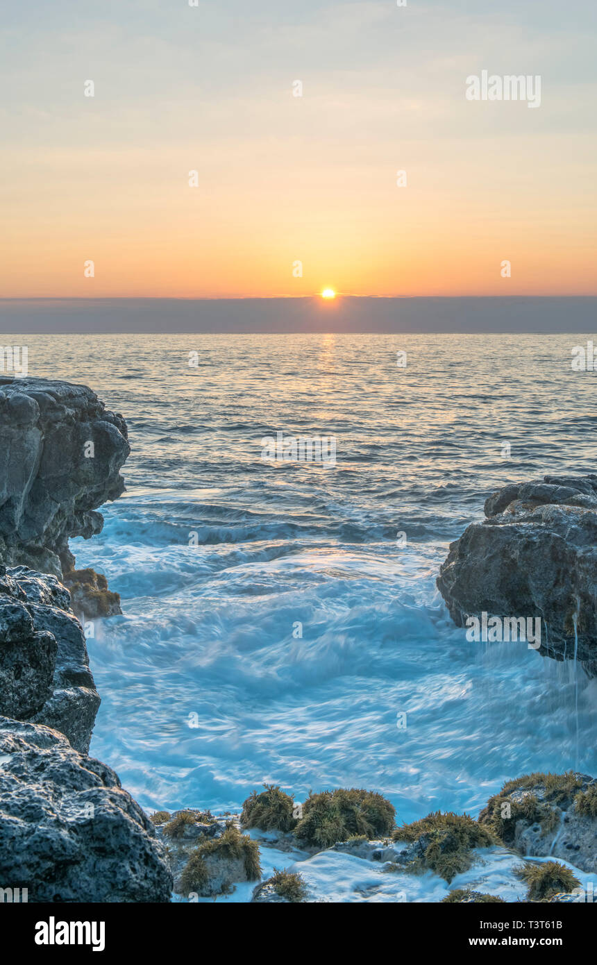 Alba sulle formazioni rocciose sulla spiaggia Foto Stock