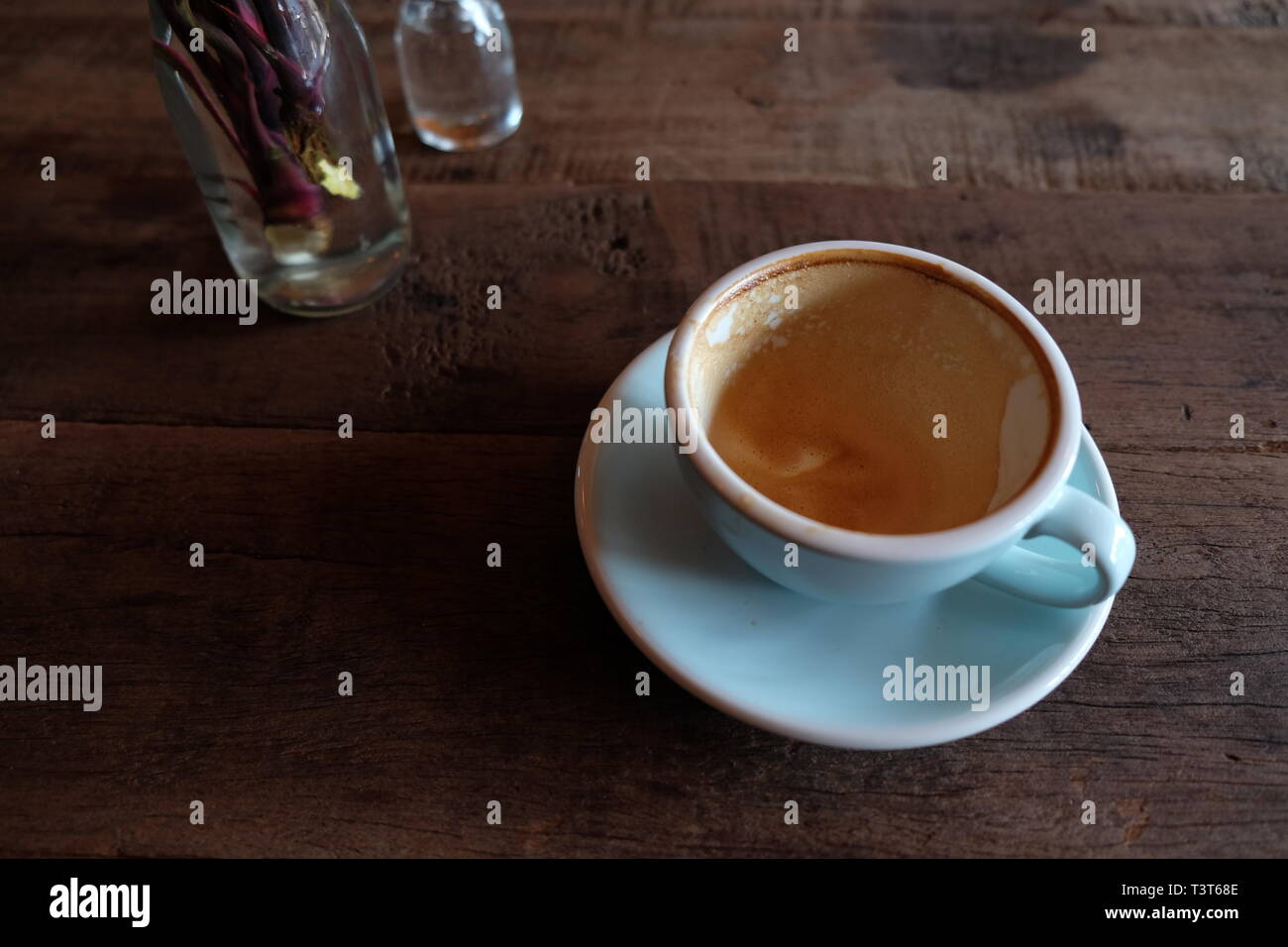 Cappuccino o latte con schiuma spumeggiante, blu tazza da caffè top sul caffè in legno sfondo shop Foto Stock