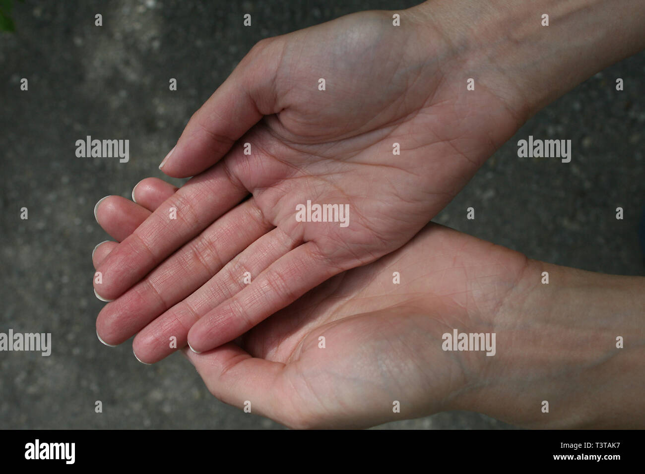 Coppia di ladies mani, uno sulla sommità dell'altro.. I palmi rivolti verso l'alto. Foto Stock