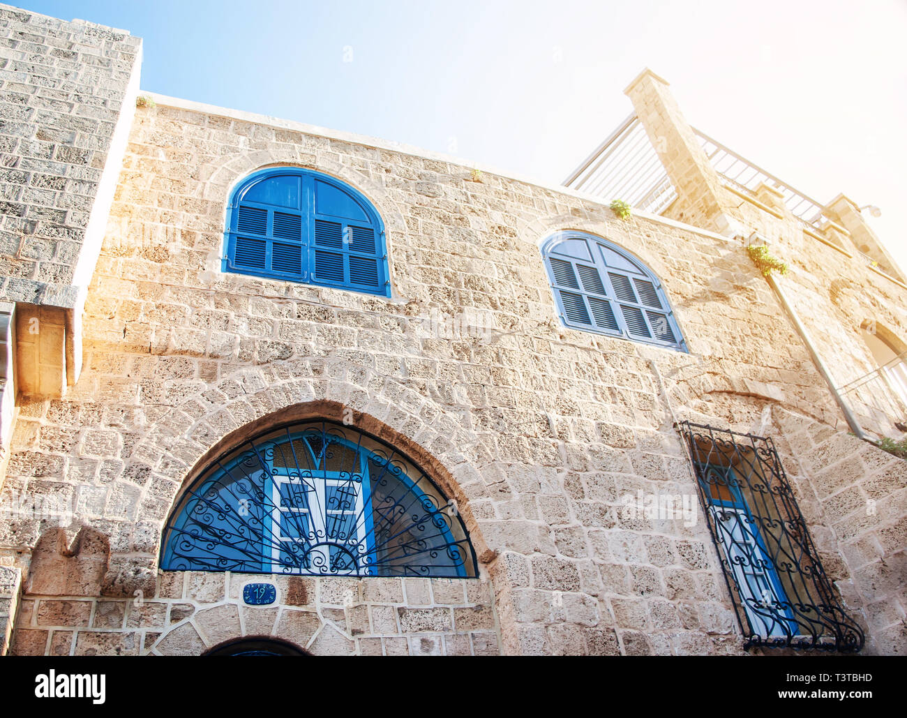Vecchia casa in Israele con finestre con persiane blu. Edificio storico. Foto Stock