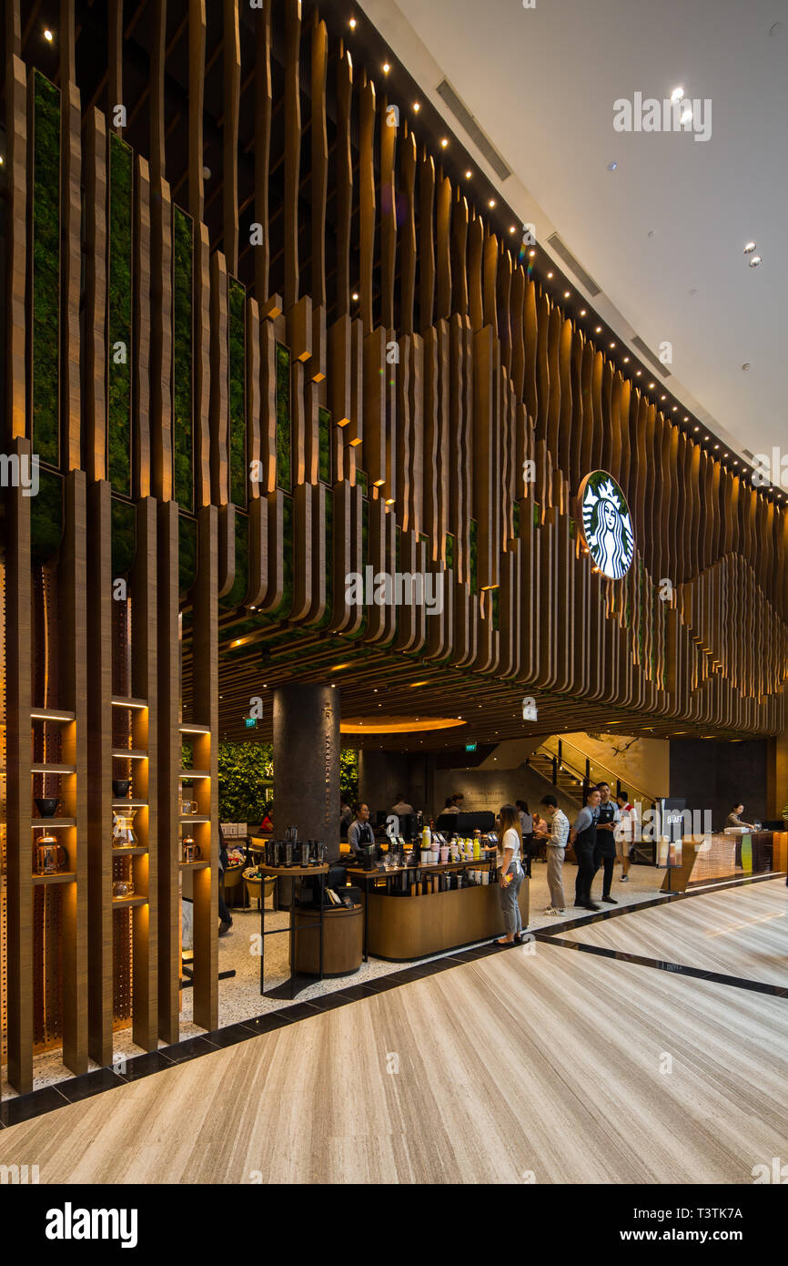 Vista verticale, il più grande Starbuck Cafe si trova presso l'aeroporto Jewel Changi. Singapore. Vista angolare laterale della facciata del negozio Foto Stock