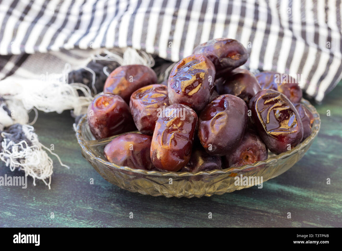 Datteri secchi Frutta in una ciotola su sfondo di legno Foto Stock