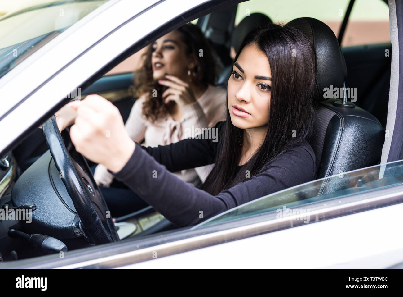 Giovane donna bionda scuotendo il suo pugno seduti nel veicolo Foto Stock