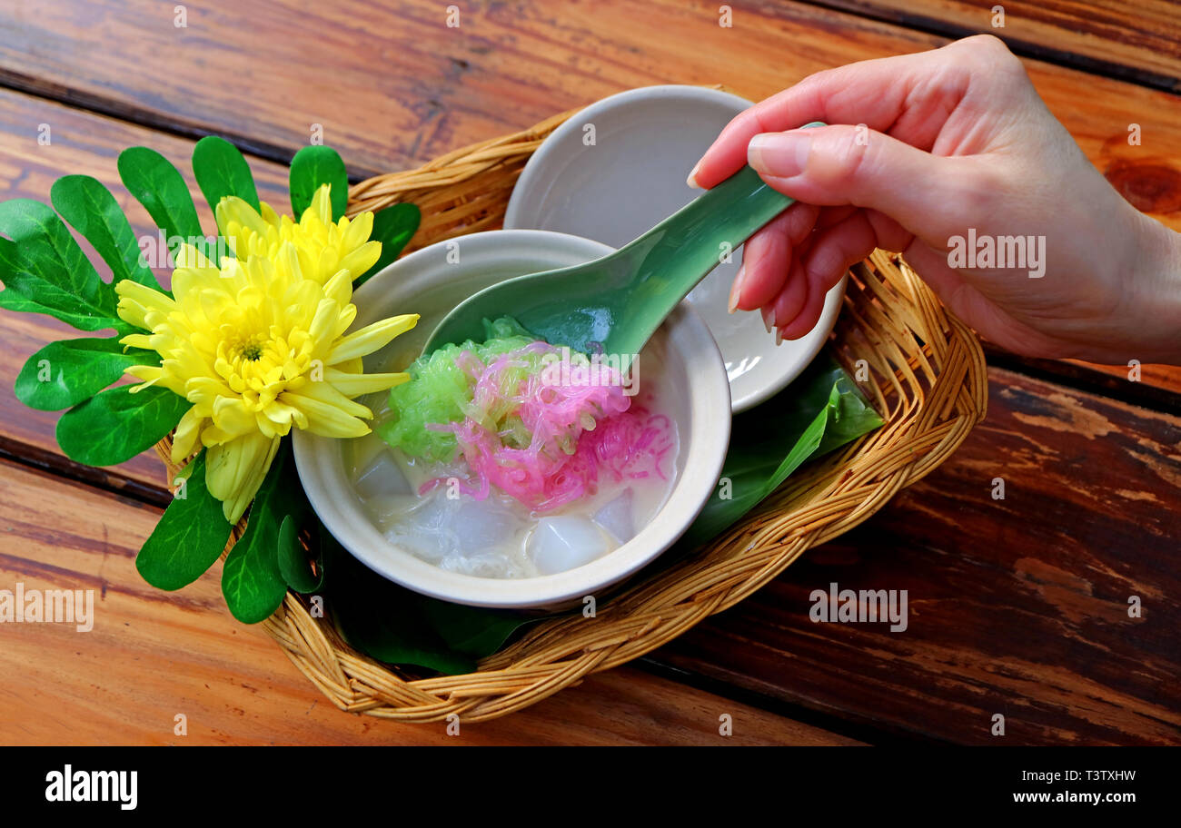 Donna di movimentazione a mano dolce refrigerate Vermicelli in latte di cocco, Thai dessert tradizionale Foto Stock