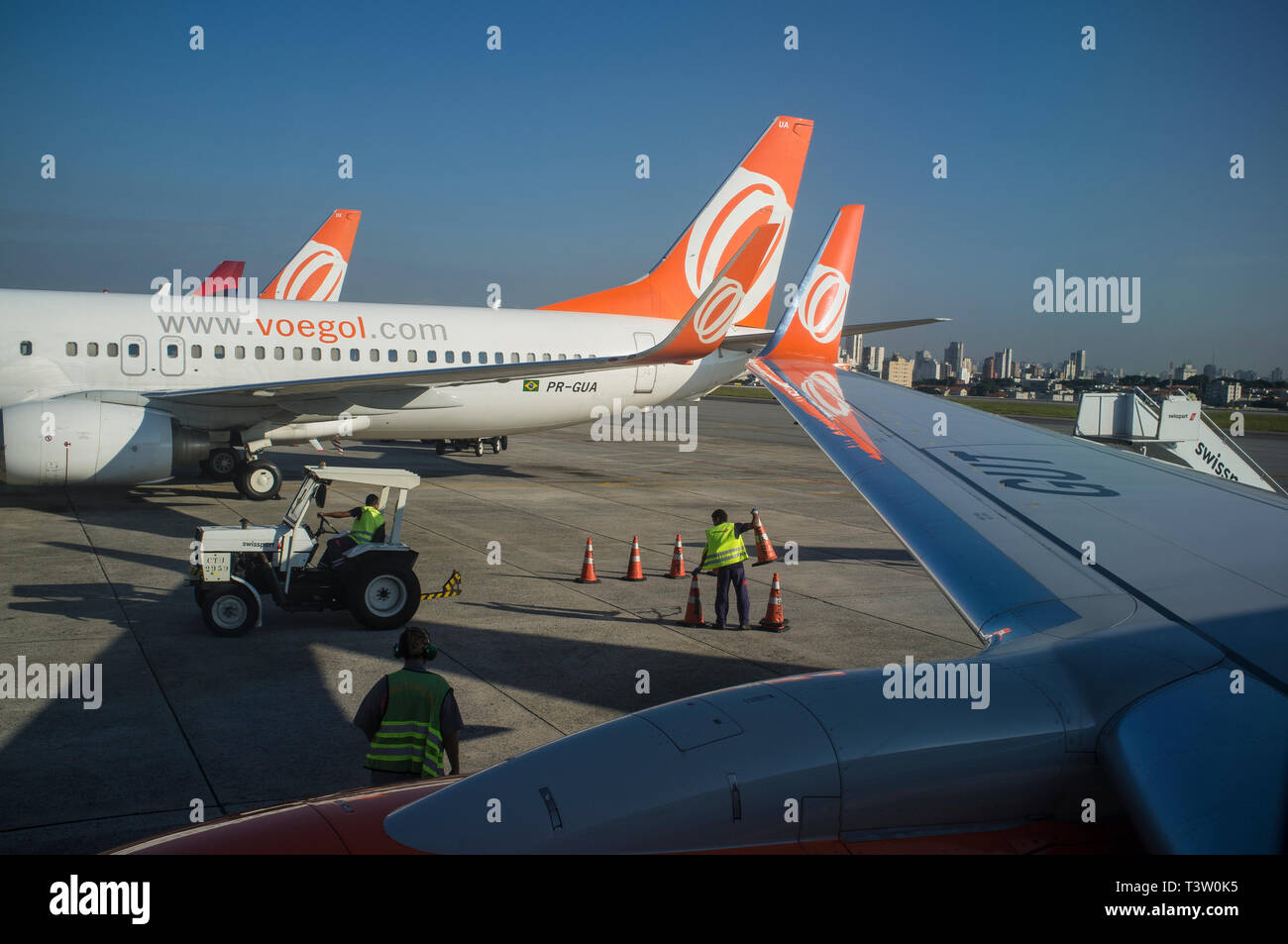 Aeroporto di Congonhas funzionamento, equipaggio a terra lavora ad aerei di atterraggio area gestione di pista di rullaggio segni ( aeroporto segnaletica di orientamento ) fornendo direzione e informazioni di rullaggio degli aeromobili e veicoli aeroportuali, Sao Paulo, Brasile. Foto Stock