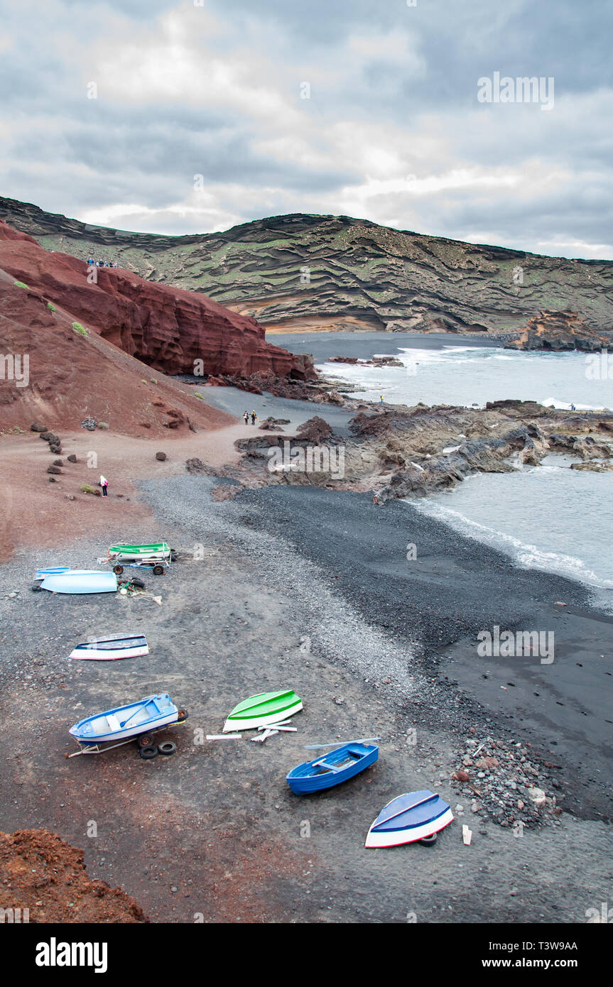 Una piccola baia vicino al villaggio di El Golfo, sull'isola di Lanzarote nelle Isole Canarie, con piccole imbarcazioni sulla spiaggia Foto Stock