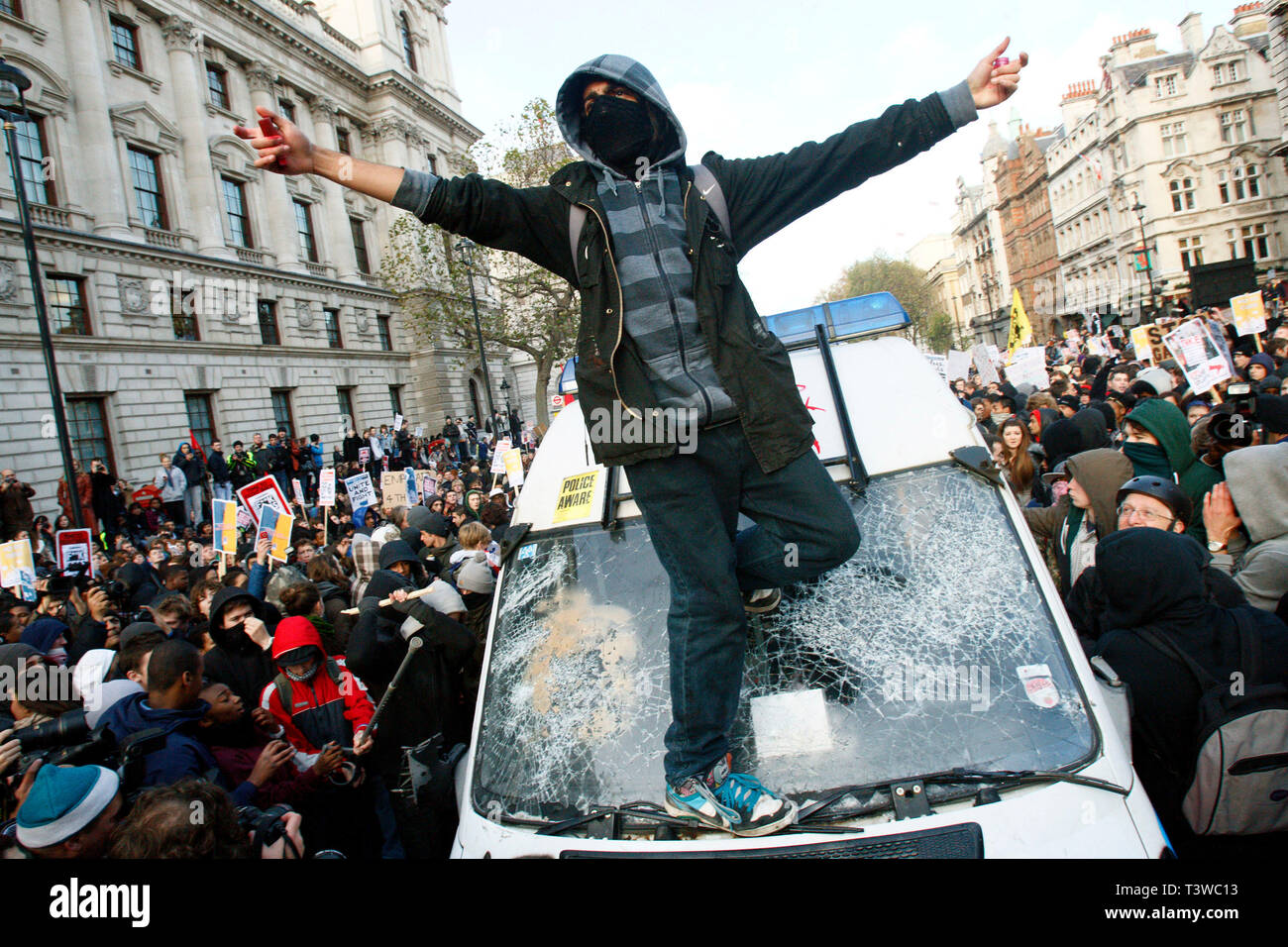 Un protetore si trova sulla finestra schiacciata di un furgone della polizia. Gli studenti protestano contro l’aumento delle tasse scolastiche e la riduzione dei finanziamenti universitari. Londra. Foto Stock Un protetore si trova sulla finestra schiacciata di un furgone della polizia. Gli studenti protestano contro l’aumento delle tasse scolastiche e la riduzione dei finanziamenti universitari. Londra. Foto Stock