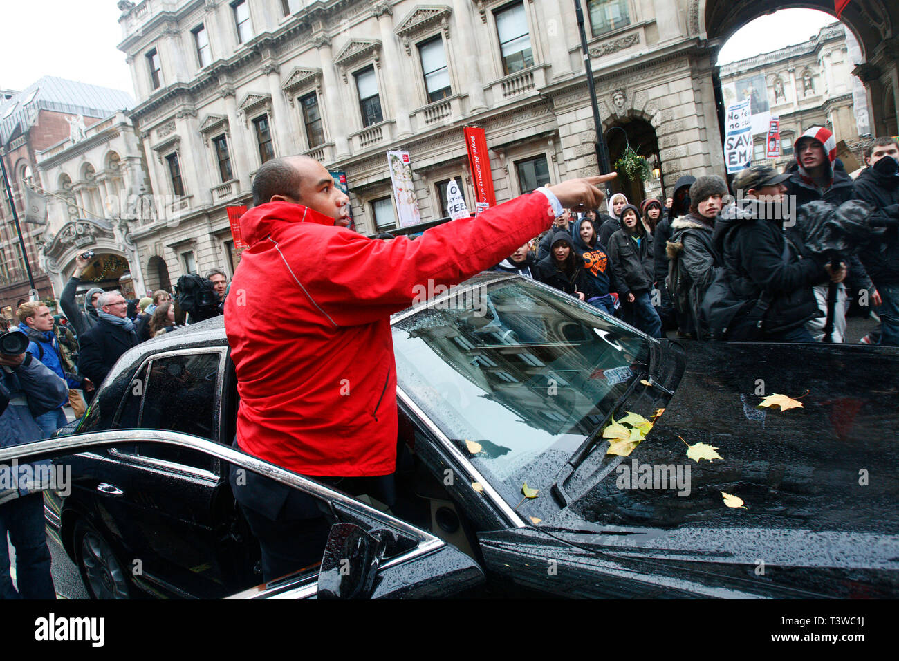 Bentley Arnage auto conducente esce e grida agli studenti come protestano contro i piani per aumentare le tasse e tagli al finanziamento delle università. Londra. Foto Stock