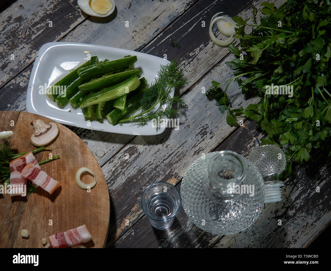 Fresche, bassa-coltivati cetrioli decorate con le cipolle verdi sono serviti. A una certa distanza, tagliare un paio di pezzi di carni suine fresche. Foto Stock