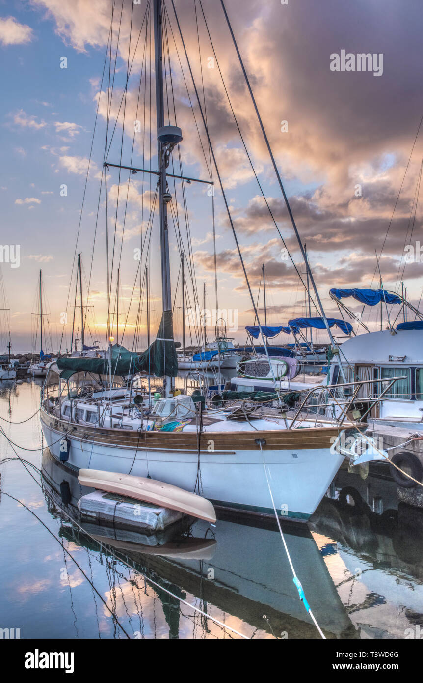 Yacht e cielo nuvoloso si riflette nel porto urbano Foto Stock