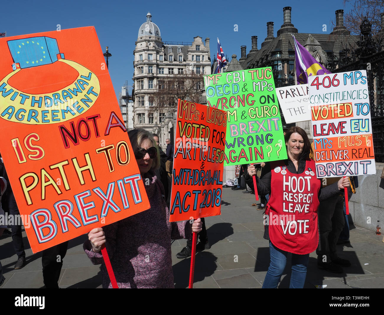 Manifestanti Pro-Brexit sventolando striscioni e cartelloni con anti-slogan dell'UE al di fuori del parlamento di Westminster a Londra Foto Stock