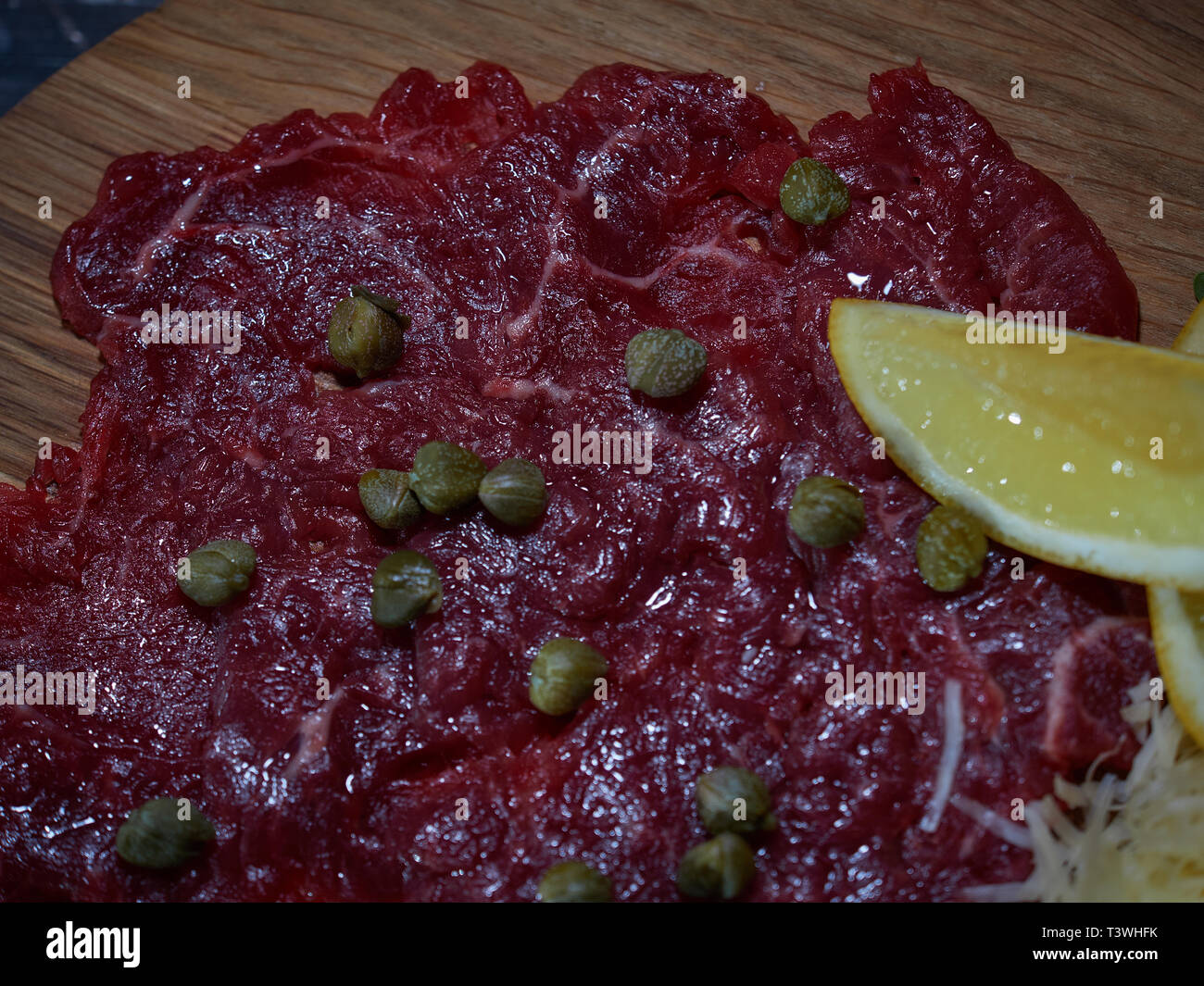 Un grande pezzo di materie di carni bovine è servita su un tavolo su un vassoio di legno con sughi di carne. Foto Stock