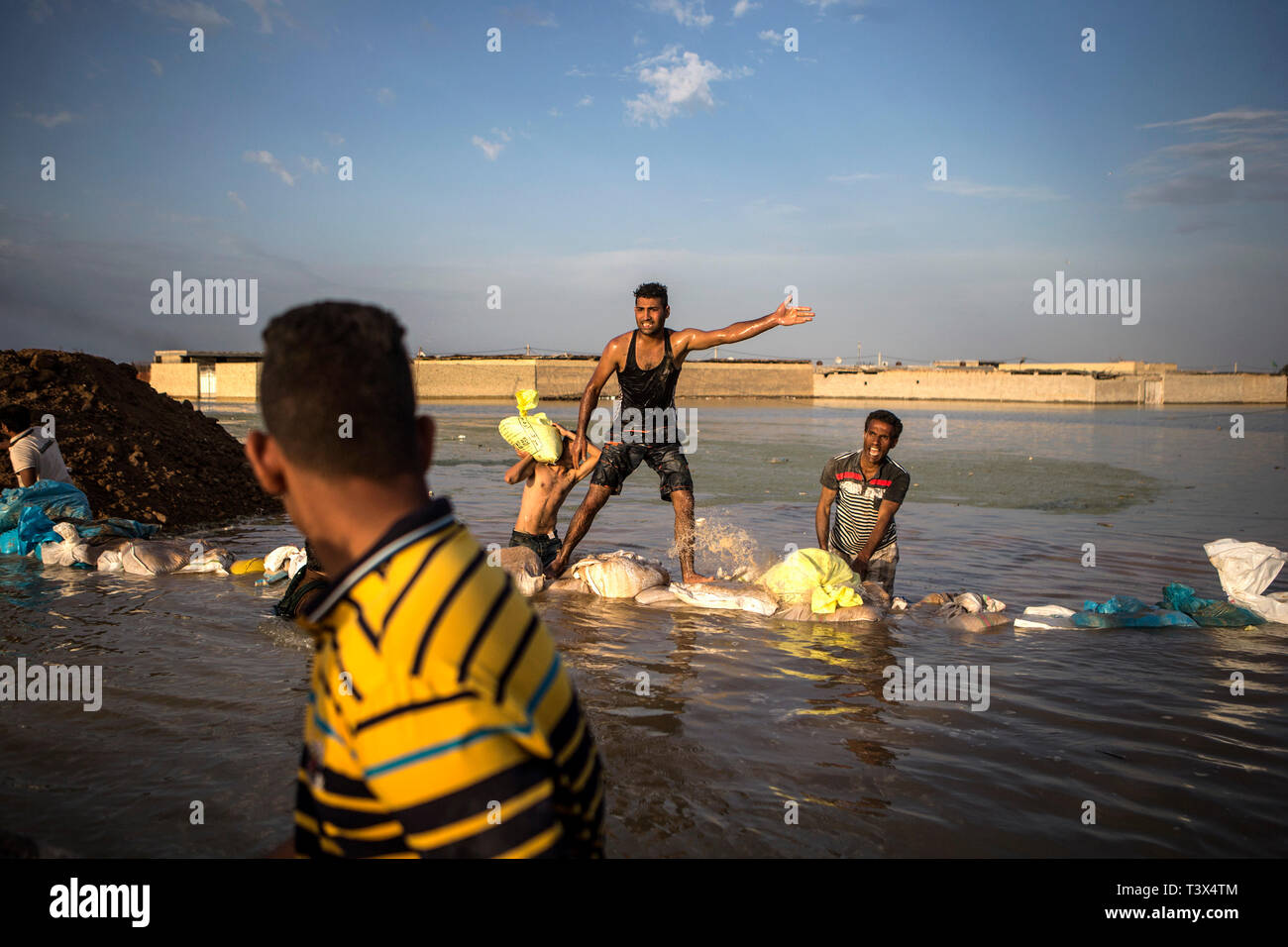 (190412) -- AHVAZ, Aprile 12, 2019 (Xinhua) -- le persone a costruire dighe fatti a mano per bloccare le acque di esondazione appena fuori città Ahvaz, capitale della provincia di Khuzestan, Iran, 11 aprile 2019. (Xinhua/Ahmad Halabisaz) Foto Stock