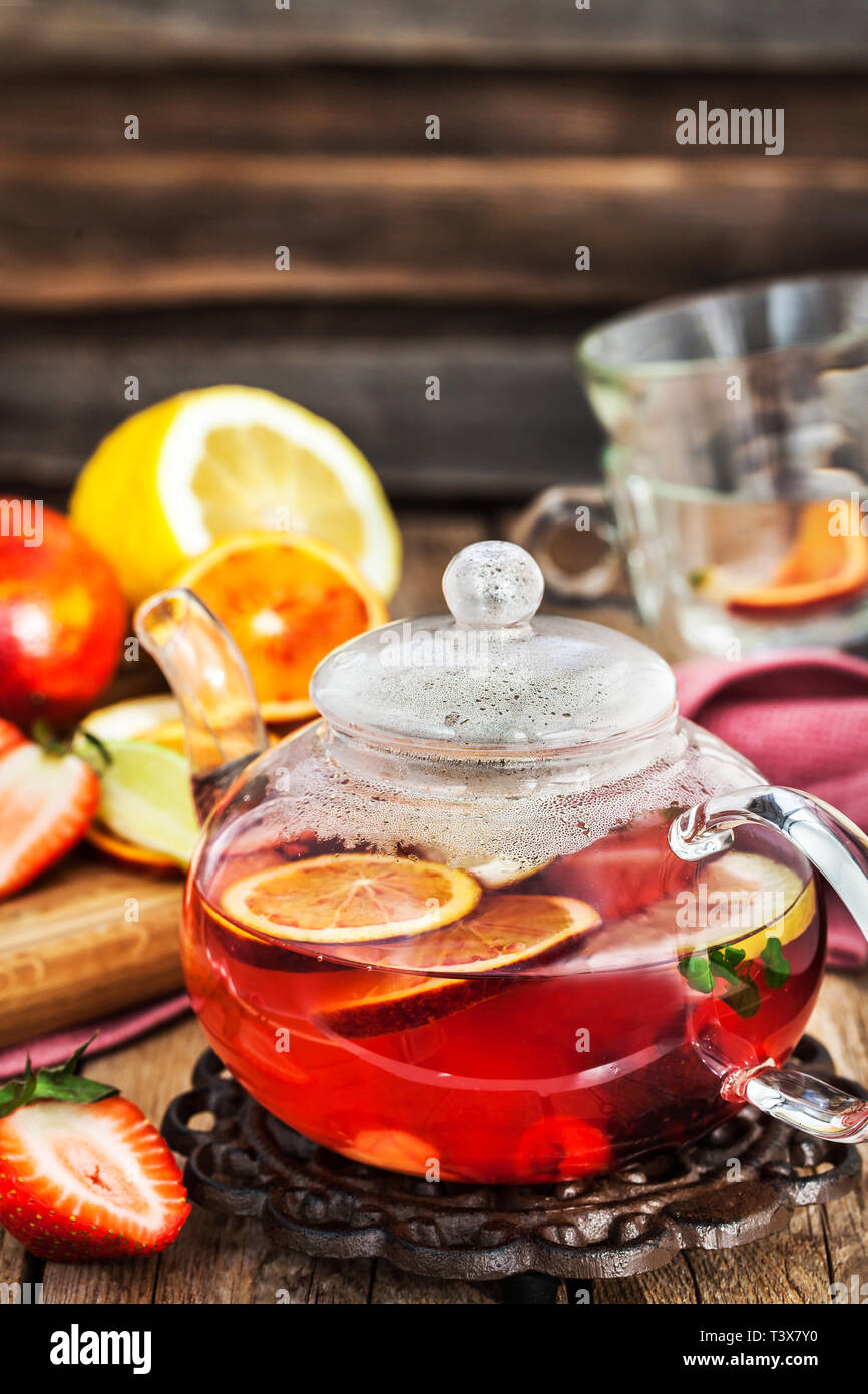 Frutta tè rosso con arance e bacche sul tavolo di legno Foto Stock