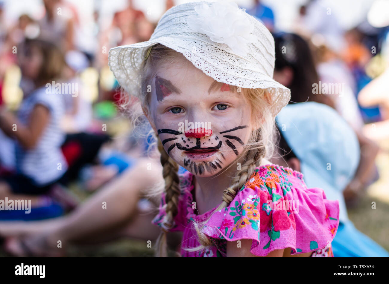 Bambina con cappello bianco con face-pittura di cat Foto Stock