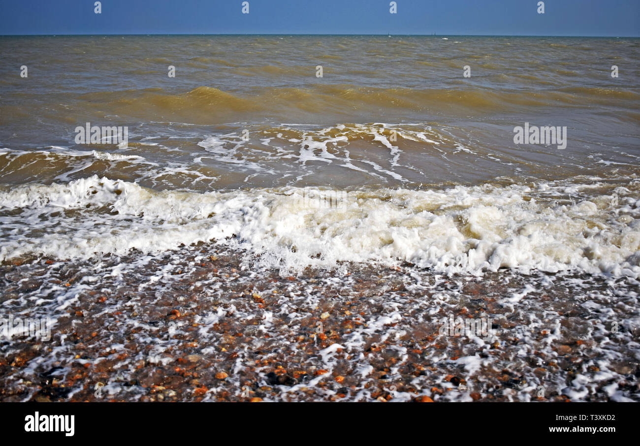 Vista sul mare dell'onda formanti mare bianco spray e le bolle che schizza sulla riva Foto Stock