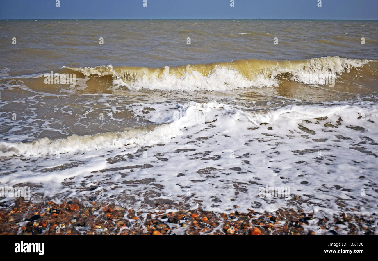 Vista sul mare dell'onda formanti mare bianco spray e le bolle che schizza sulla riva Foto Stock