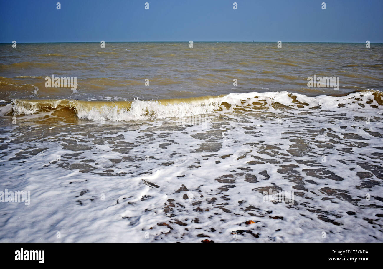 Vista sul mare dell'onda formanti mare bianco spray e le bolle che schizza sulla riva Foto Stock