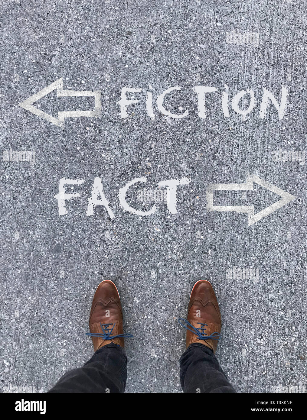 Uomo in piedi di fronte a due frecce e le parole "fiction" e "Fatto" Foto Stock