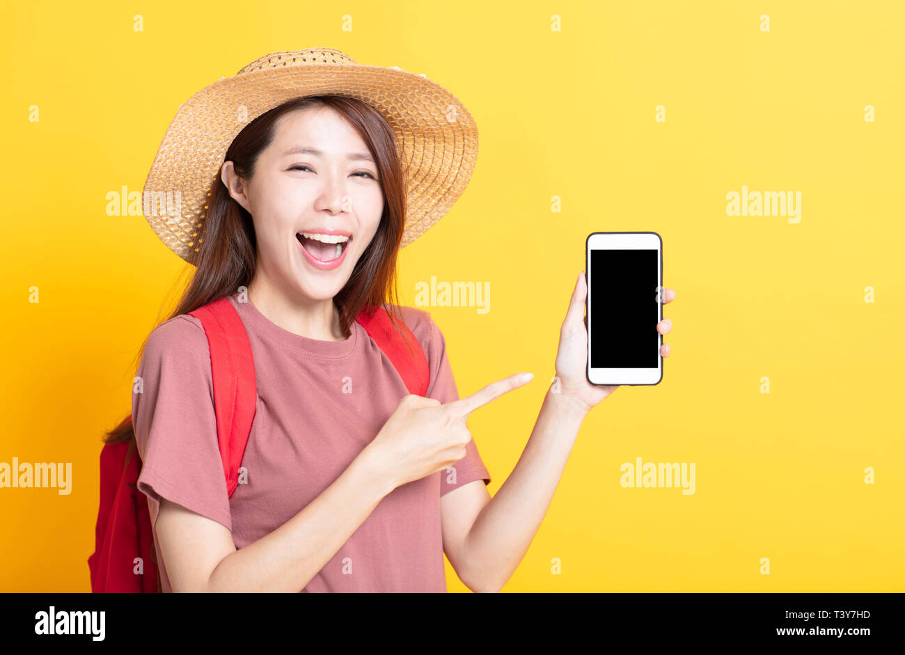 Felice giovane donna in estate hat e mostrando smart phone Foto Stock