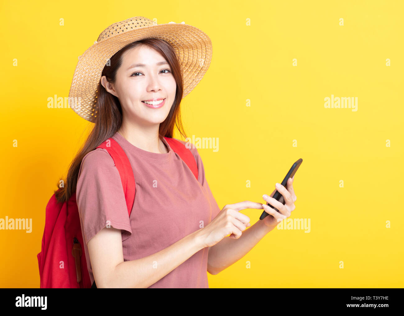 Sorridente giovane donna in estate hat e utilizzo di smart phone Foto Stock