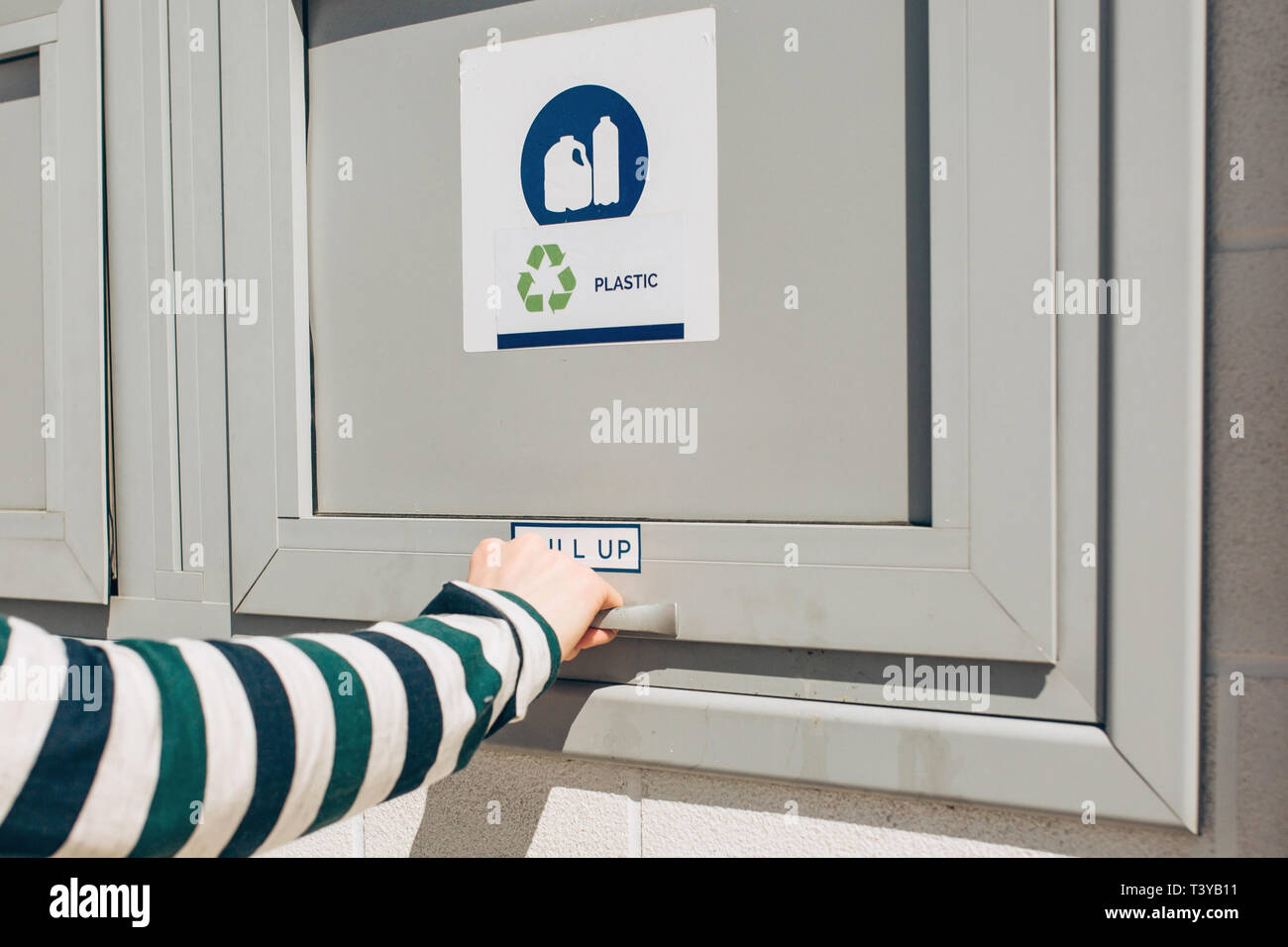Una persona che si apre o si chiude un moderno bidone dei rifiuti per la raccolta differenziata dei rifiuti. Foto Stock