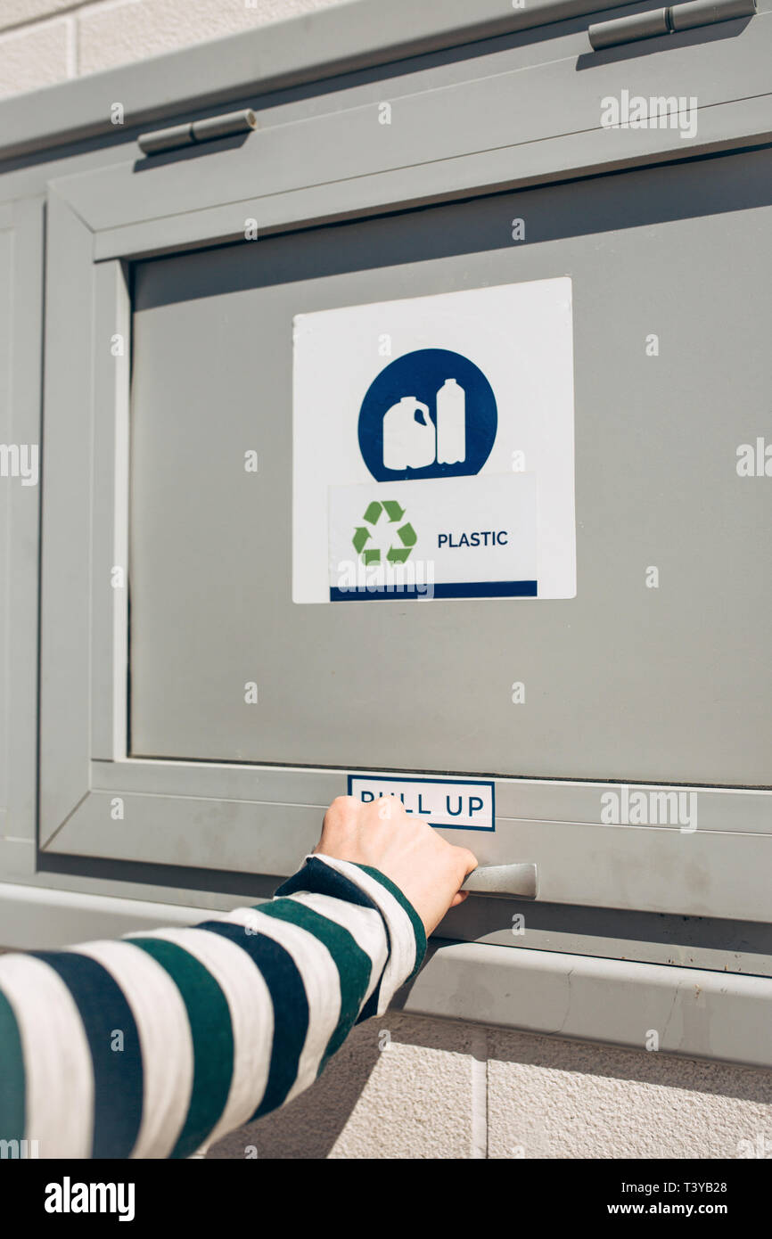 Una persona che si apre o si chiude un moderno bidone dei rifiuti per la raccolta differenziata dei rifiuti. Foto Stock