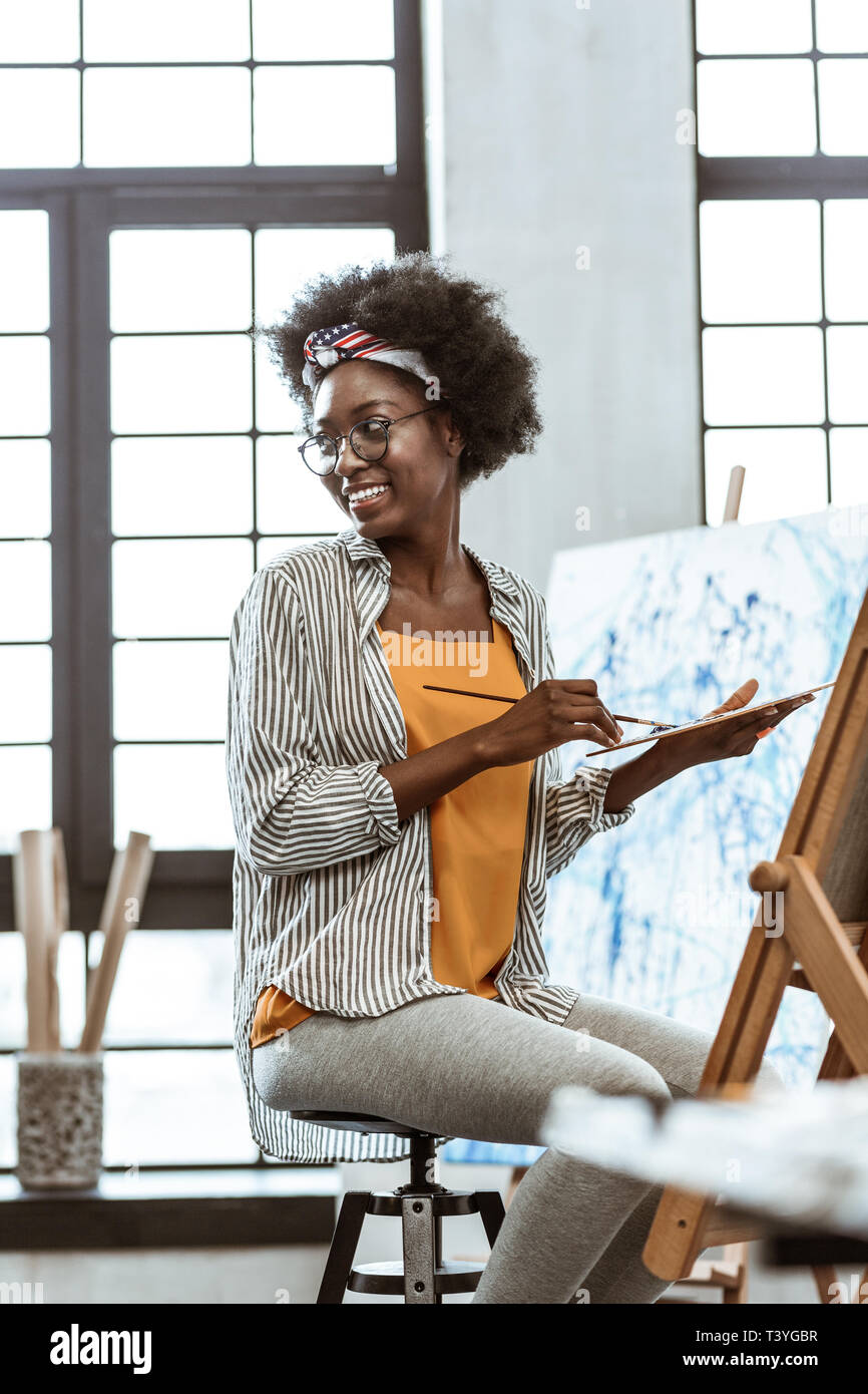 Pittura in officina. Art Student indossa gambali grigio e camicia a righe pittura in officina Foto Stock