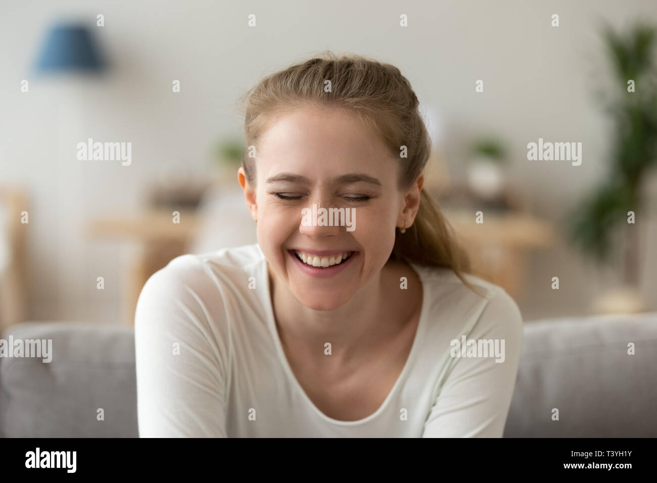 Close up attraente giovane donna ridere con gli occhi chiusi Foto Stock